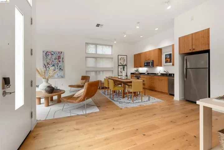 Open-concept living area featuring wood-finish flooring, high ceilings, and recessed lighting