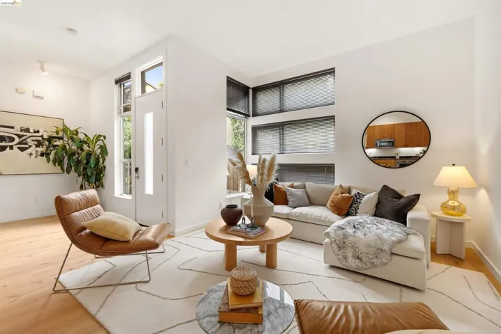 Light wood-finish flooring complements the neutral color palette throughout this living area