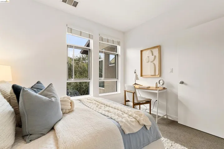 Room with large windows providing ample natural light, light-colored walls, and neutral-toned carpeting