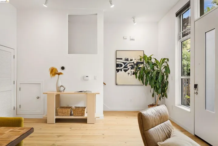 Entryway featuring light wood-finish flooring, a tall, narrow window, and track lighting