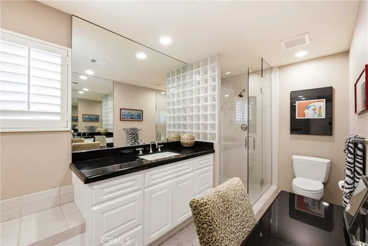 Primary bathroom w/separate shower, spa tub & vanity table.