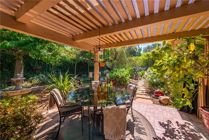 Serene covered patio overlooking the lush, water-wise backyard.