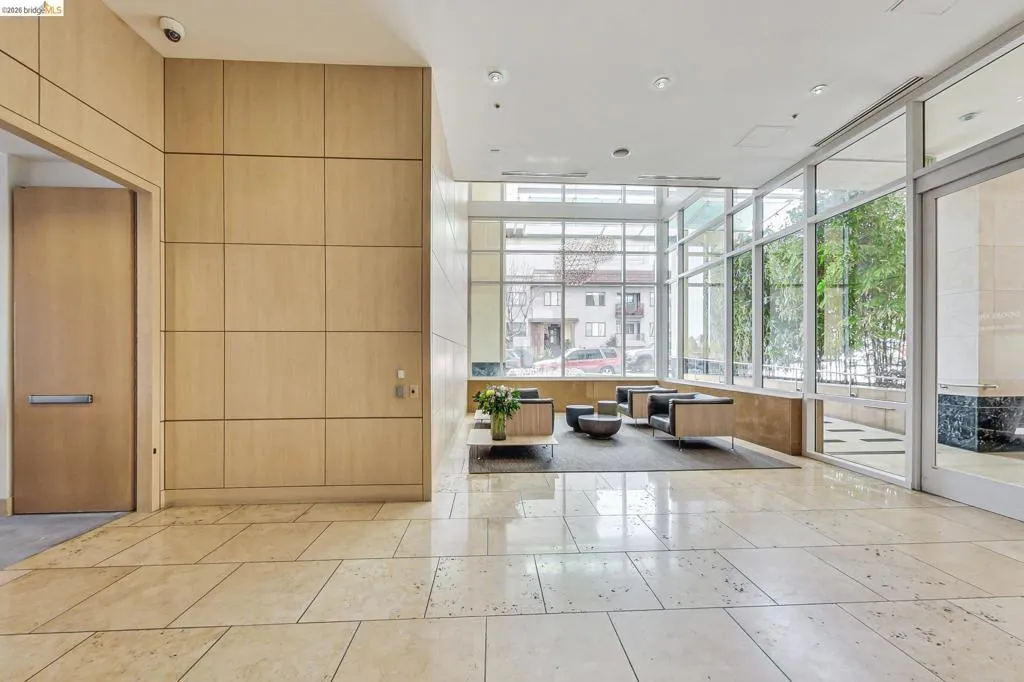 Lobby area featuring large format tile flooring, extensive wood paneling, and a seating arrangement with a low coffee table