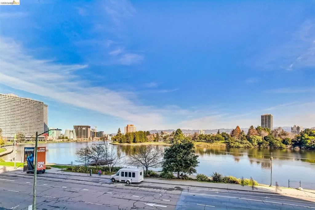 Waterfront panorama featuring a cityscape backdrop, extensive body of water, and distant hills