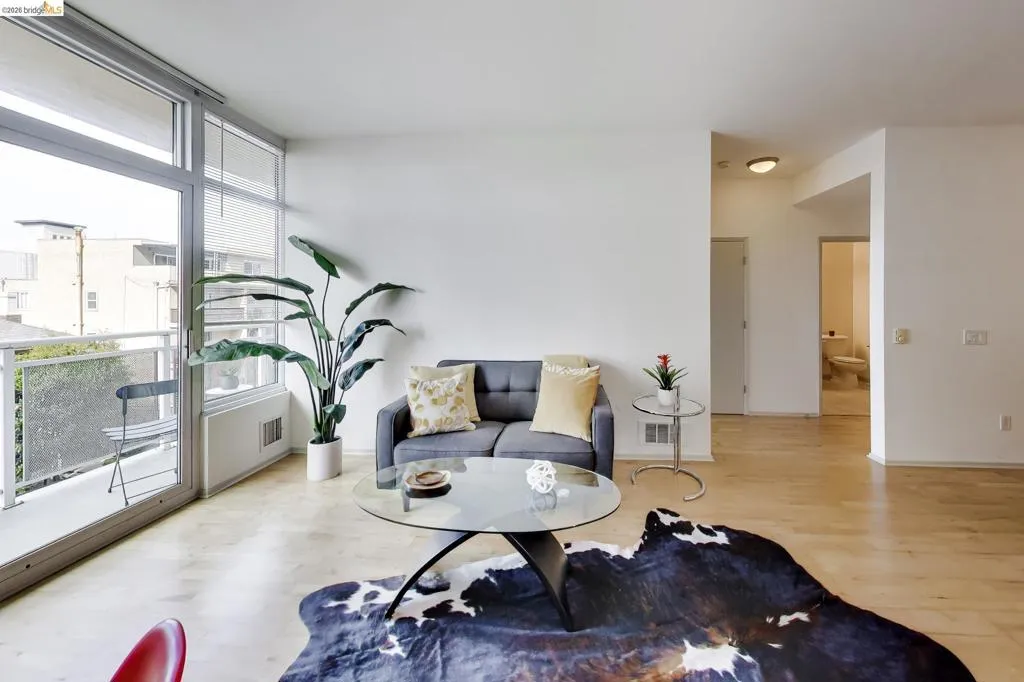Expansive glass sliding doors open to a private balcony with a metal railing