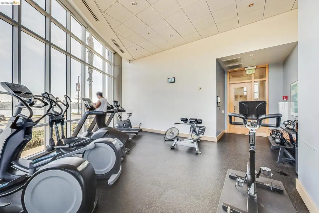 Fitness center featuring large floor-to-ceiling windows, recessed lighting, and rubberized flooring