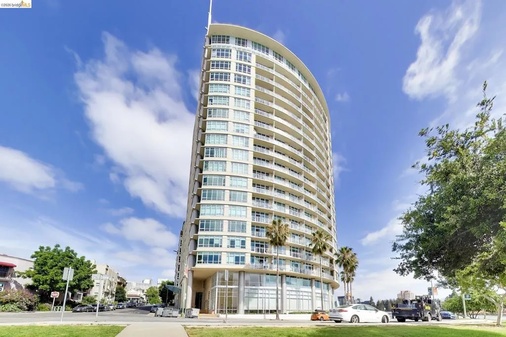 Contemporary high-rise building featuring a curved facade and multiple balconies