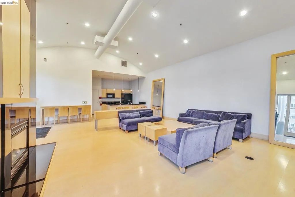 Expansive open-concept room featuring high vaulted ceilings, recessed lighting, and light-toned flooring