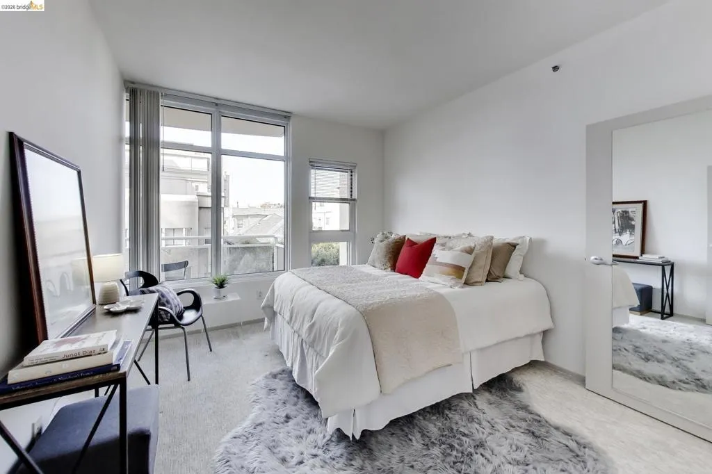 Light-filled interior featuring expansive windows, wood-finish flooring, and crisp white walls