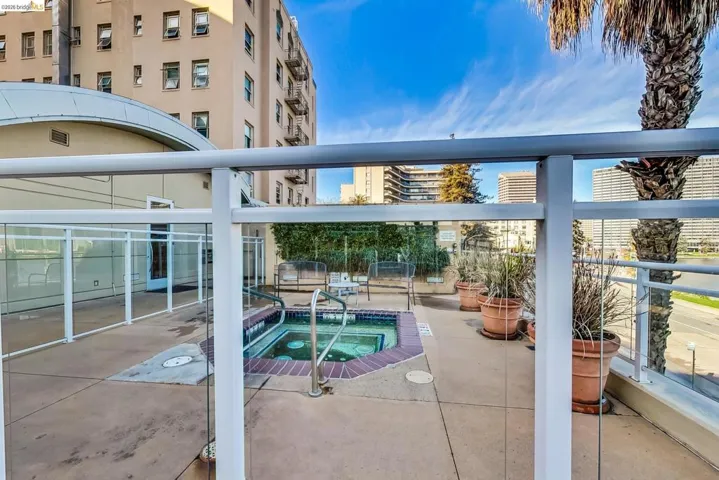Rooftop terrace with an in-ground hot tub featuring brick coping and stainless steel grab rails