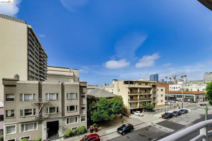 Cityscape featuring multiple residential buildings, urban street, and distant architectural structures