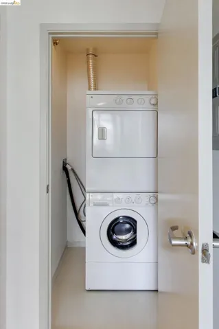 Dedicated laundry closet with stacked white washer and dryer unit