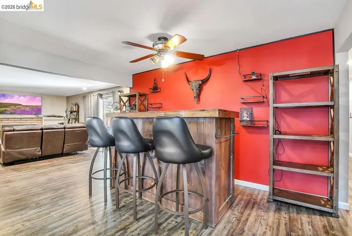 Custom wood-finish bar area featuring a wood-finish countertop and three bar stools