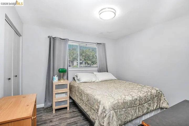 Room featuring wood-finish flooring, a double-pane window, and a flush-mount ceiling light fixture