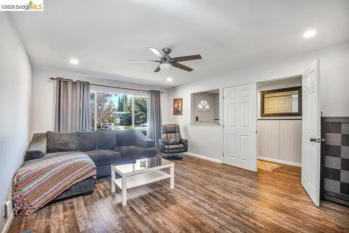 Living area featuring wood-finish flooring, recessed lighting, and a ceiling fan