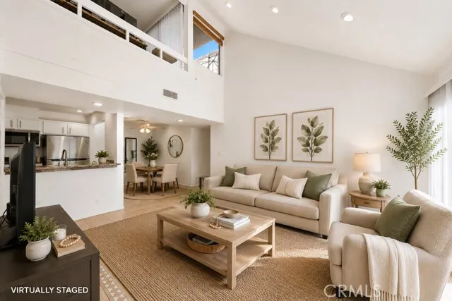 Spacious living room with vaulted ceilings and an abundance of natural light. (virtually staged)