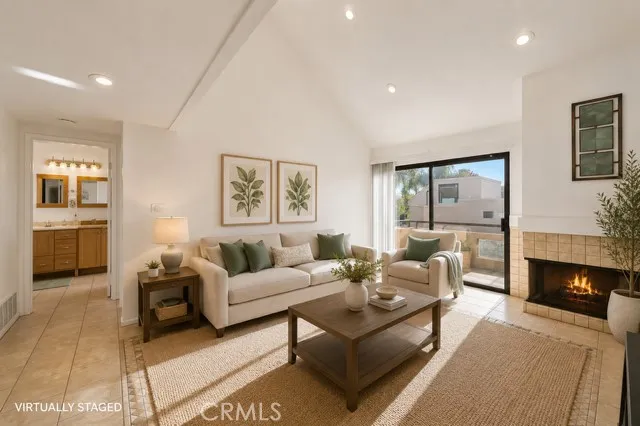 Another view of the living room with fireplace and balcony #1 (virtually staged)