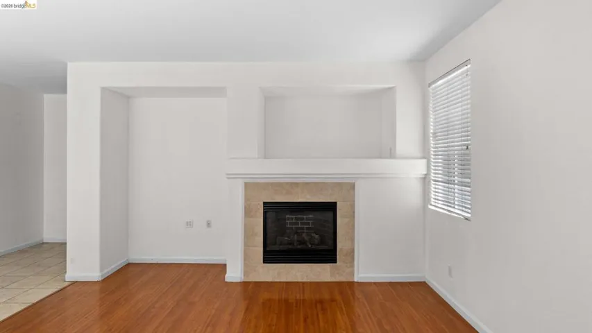 Fireplace featuring a stone tile surround and white mantel with built-in niches above