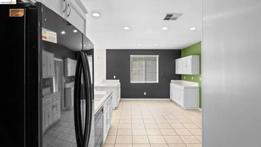 Kitchen featuring white cabinetry, light-colored countertops, and tile flooring
