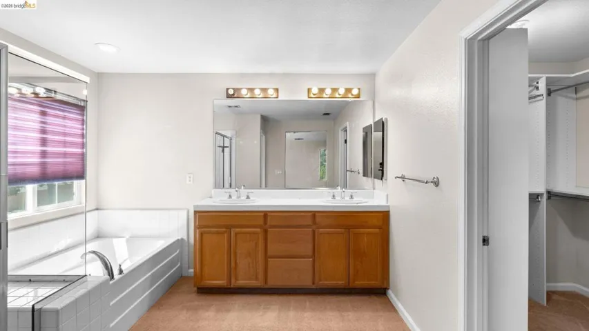 Bathroom featuring a dual sink vanity with a white countertop and wood-finish cabinetry