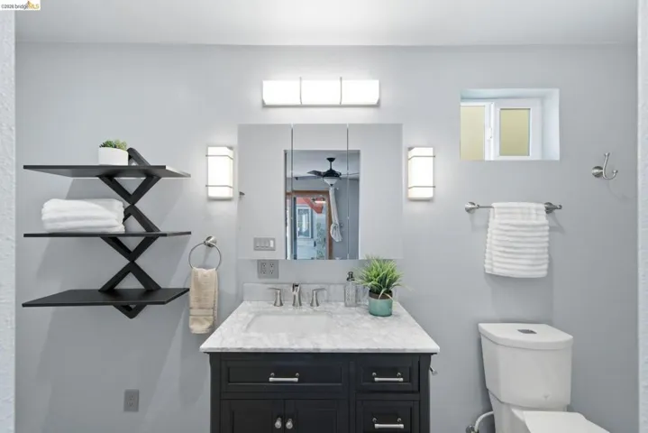 Bathroom featuring a dark wood vanity with a white stone countertop and undermount sink