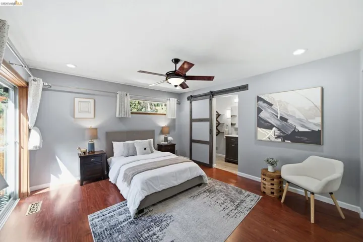 Bedroom featuring rich wood-finish flooring, light gray wall paint, and recessed lighting