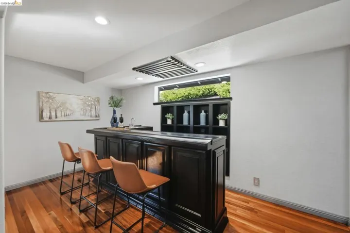Built-in wet bar featuring dark wood-finish cabinetry, a recessed sink, and an integrated storage hutch