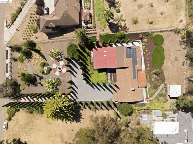 Expansive property featuring a large residence, a paved driveway, and multiple landscaped areas