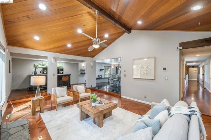 Vaulted wood-paneled ceiling with exposed beam, recessed lighting, and a ceiling fan