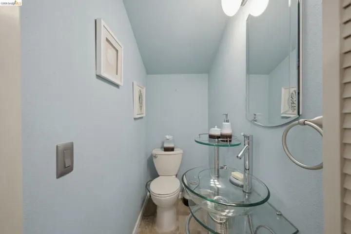 Pedestal glass sink with chrome fixtures and wall-mounted mirror