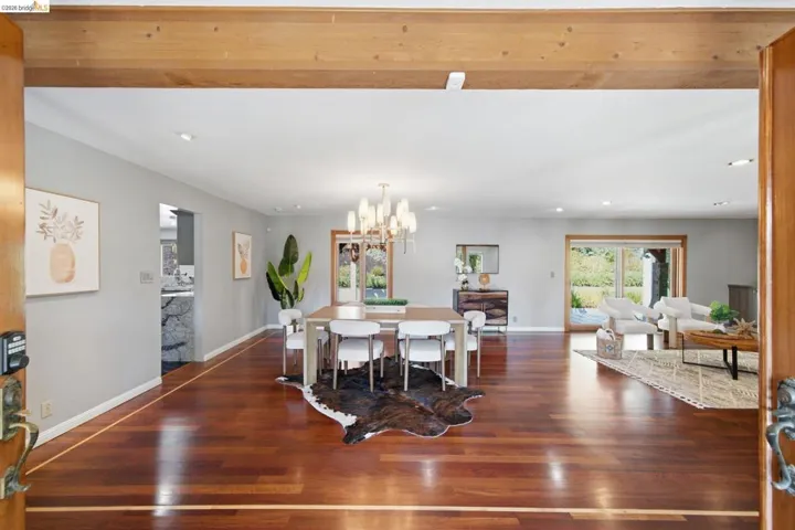 Open concept living space featuring rich wood-finish flooring, recessed lighting, and light gray walls