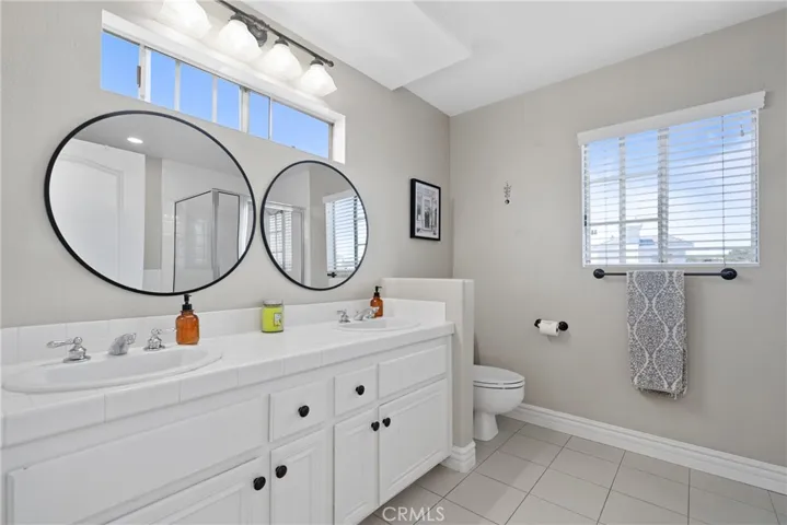 Large en-suite bathroom with dual sinks offer style and convenience.