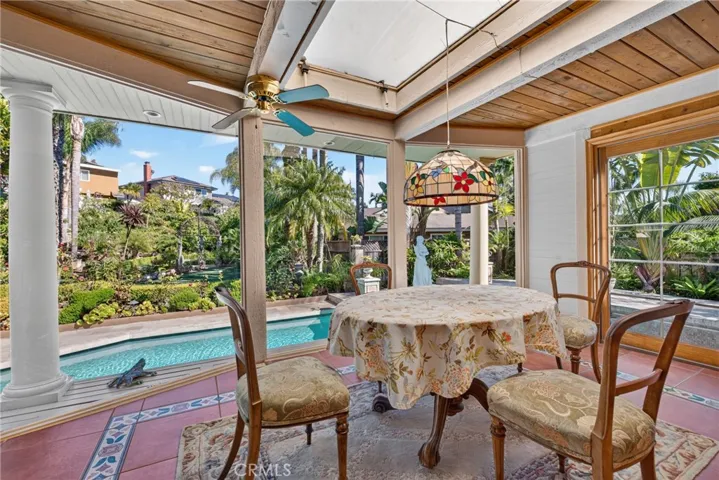 Expanded sunroom/breakfast area overlooking oversized pool & and huge back yard garden organic sanctuary/refuge filled exquisite, lush and vibrant plants and flowers.