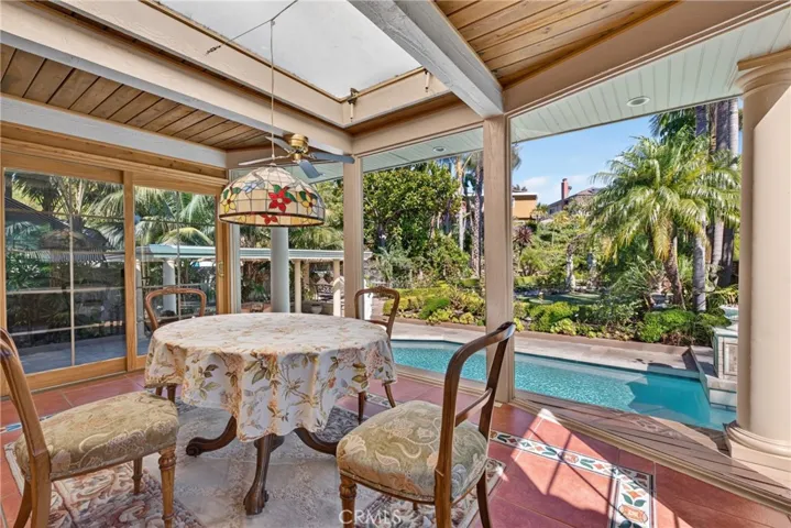 Expanded sunroom/breakfast area overlooking oversized pool & and huge back yard garden organic sanctuary/refuge filled exquisite, lush and vibrant plants and flowers.