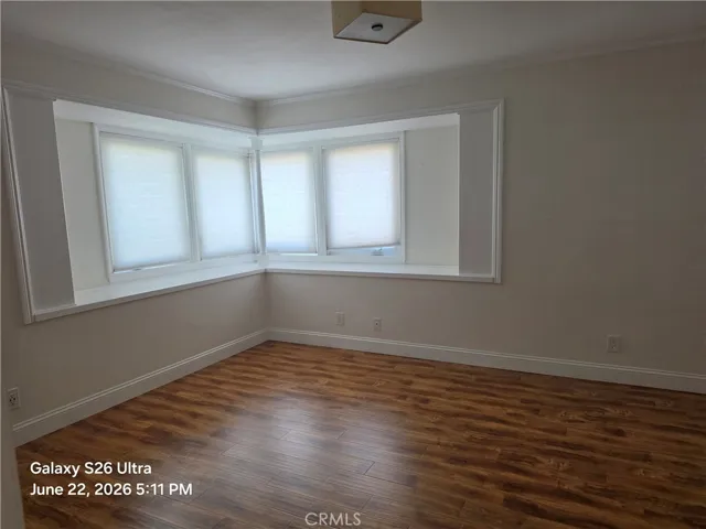 Primary bedroom has wonderful corner windows and mirrored wardrobe doors.