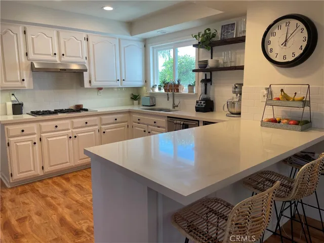 Clean, white kitchen makes food prep a pleasure Gas cooktop, beverage frig, and dishwasher