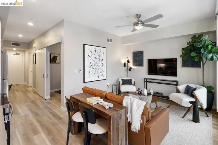 Open-concept living area featuring light wood-finish flooring, recessed lighting, and a contemporary ceiling fan