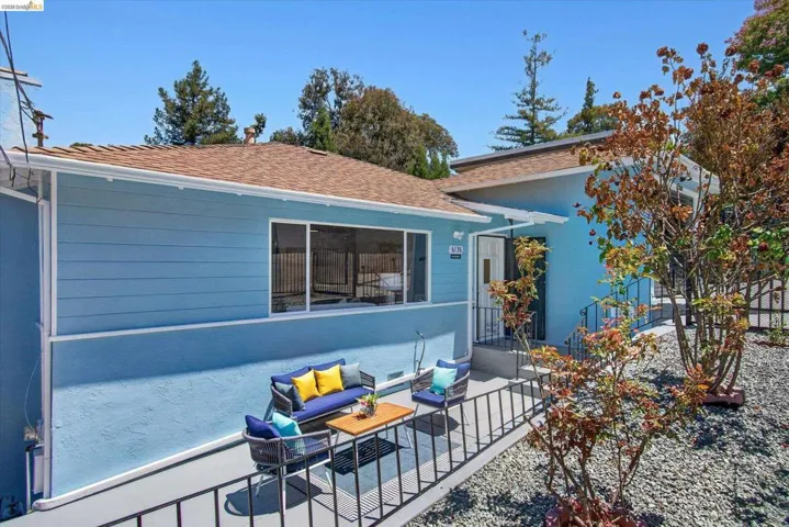Light blue exterior with horizontal siding and stucco finishes, featuring a brown shingle roof