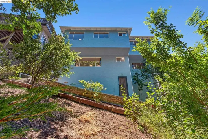 Multi-level contemporary exterior with light blue siding and multiple window placements