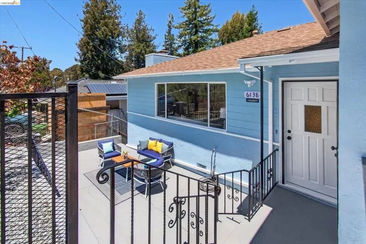 Exterior featuring light blue siding, a brown shingle roof, and a white paneled front door with a frosted glass insert