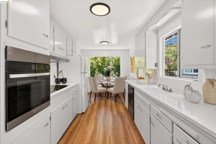 Galley kitchen featuring wood-finish flooring and recessed lighting