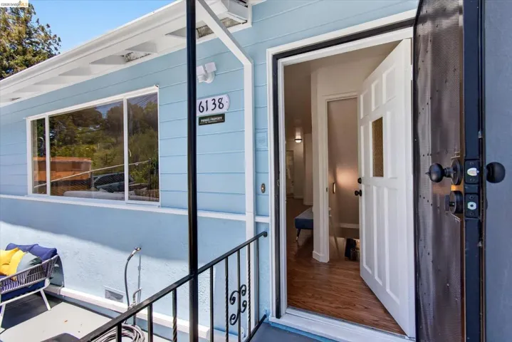Entryway featuring a white paneled door with a privacy glass insert, wood-finish flooring, and a black security screen door