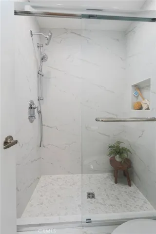 The Primary Bathroom features a Brand-New Walk-in Shower with Custom tile Surround and Seamless Glass Enclosure.