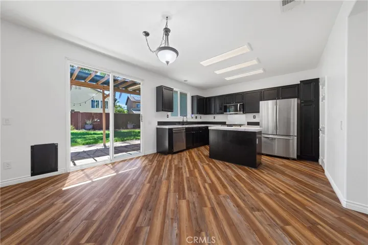 Open Kitchen And Living Area Filled With Natural Light And Backyard Views