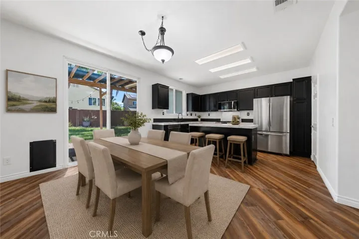 Open Kitchen And Living Area Filled With Natural Light And Backyard Views - Digitally Staged