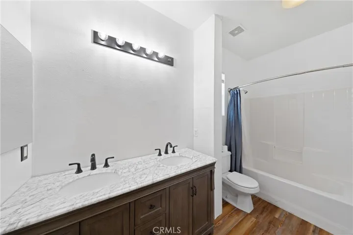 Upstairs Full Bathroom Featuring Dual Vanities And Tub/Shower Combination