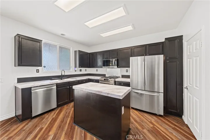 Gourmet Kitchen Featuring Large Center Island, Stainless Steel Appliances, And Ample Cabinetry - Digitally Staged