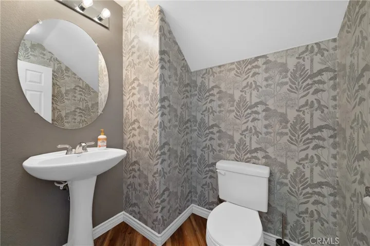 Stylish Powder Room With Designer Wallpaper And Pedestal Sink