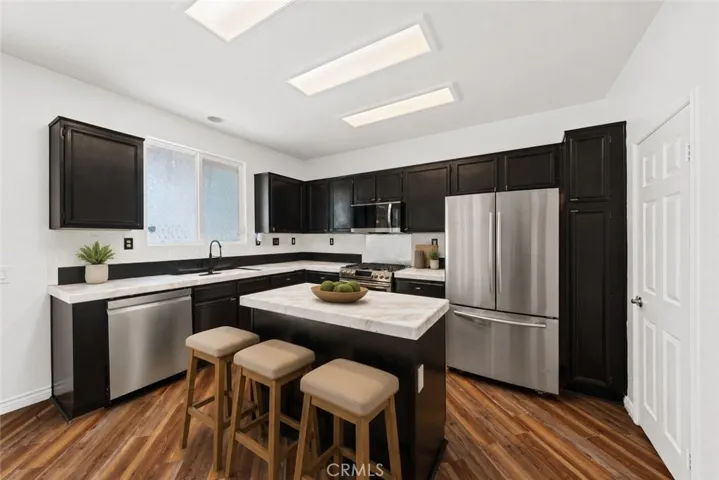 Gourmet Kitchen Featuring Large Center Island, Stainless Steel Appliances, And Ample Cabinetry - Digitally Staged
