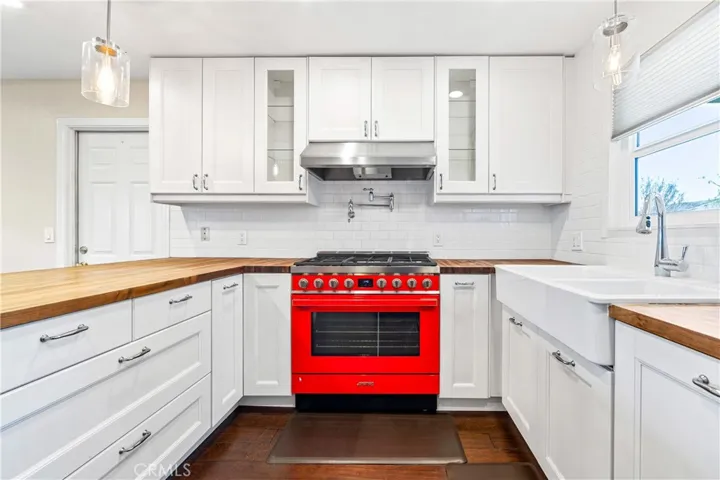 Light-filled gourmet kitchen featuring a 36-inch Smeg gas range, butcher block island, and beautiful custom finishes